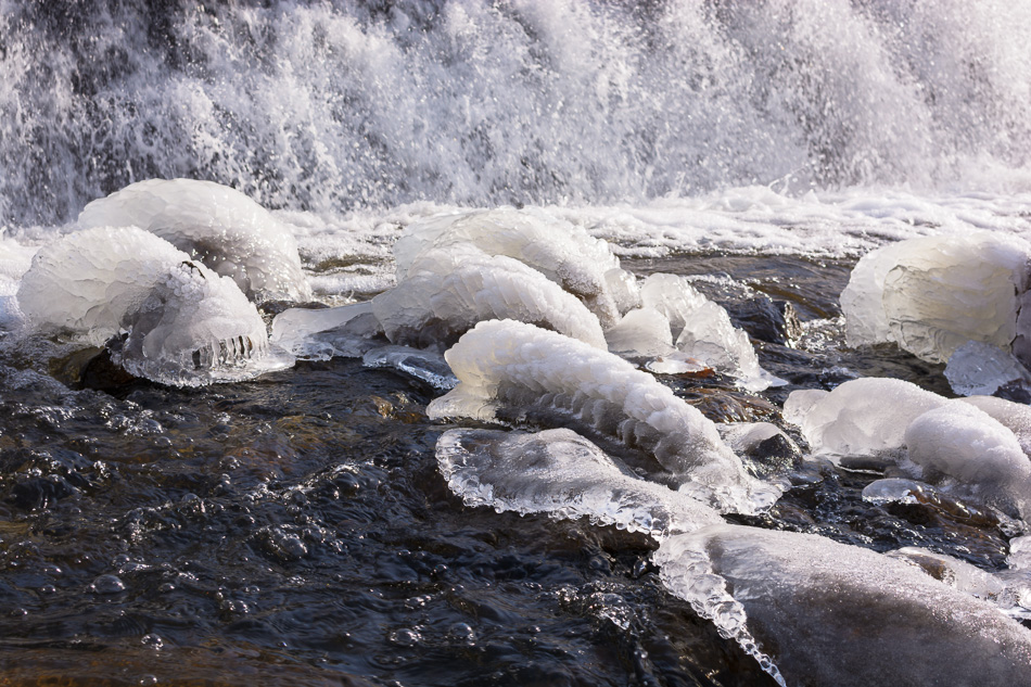 Color photo of ice-covered rocks at the base of a waterfall on the Ashuelot River in Keene, NH