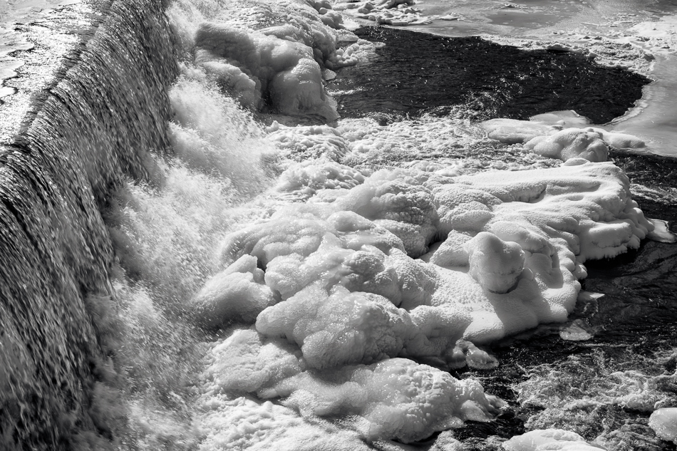 Photo of water spilling onto icy formations at the base of the Ashuelot River Dam in Keene, NH