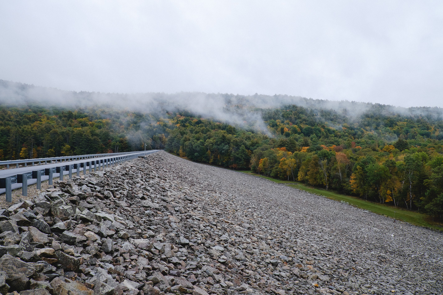 Color photo of the rocky Southern slope of Surry Mountain Dam