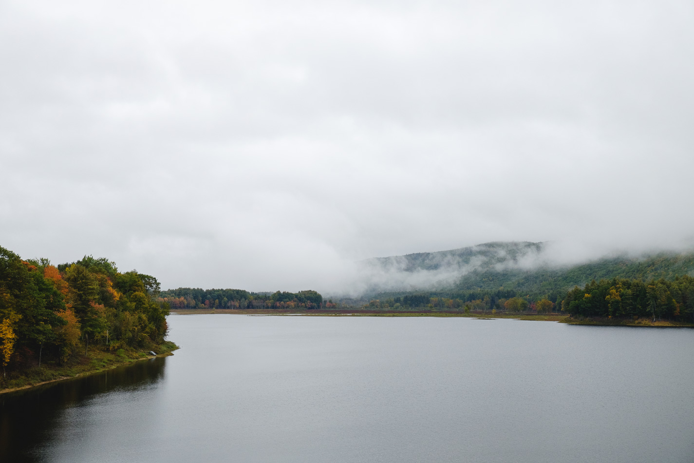 Color photo of Fall foliage and fog on Surry Mountain Lake