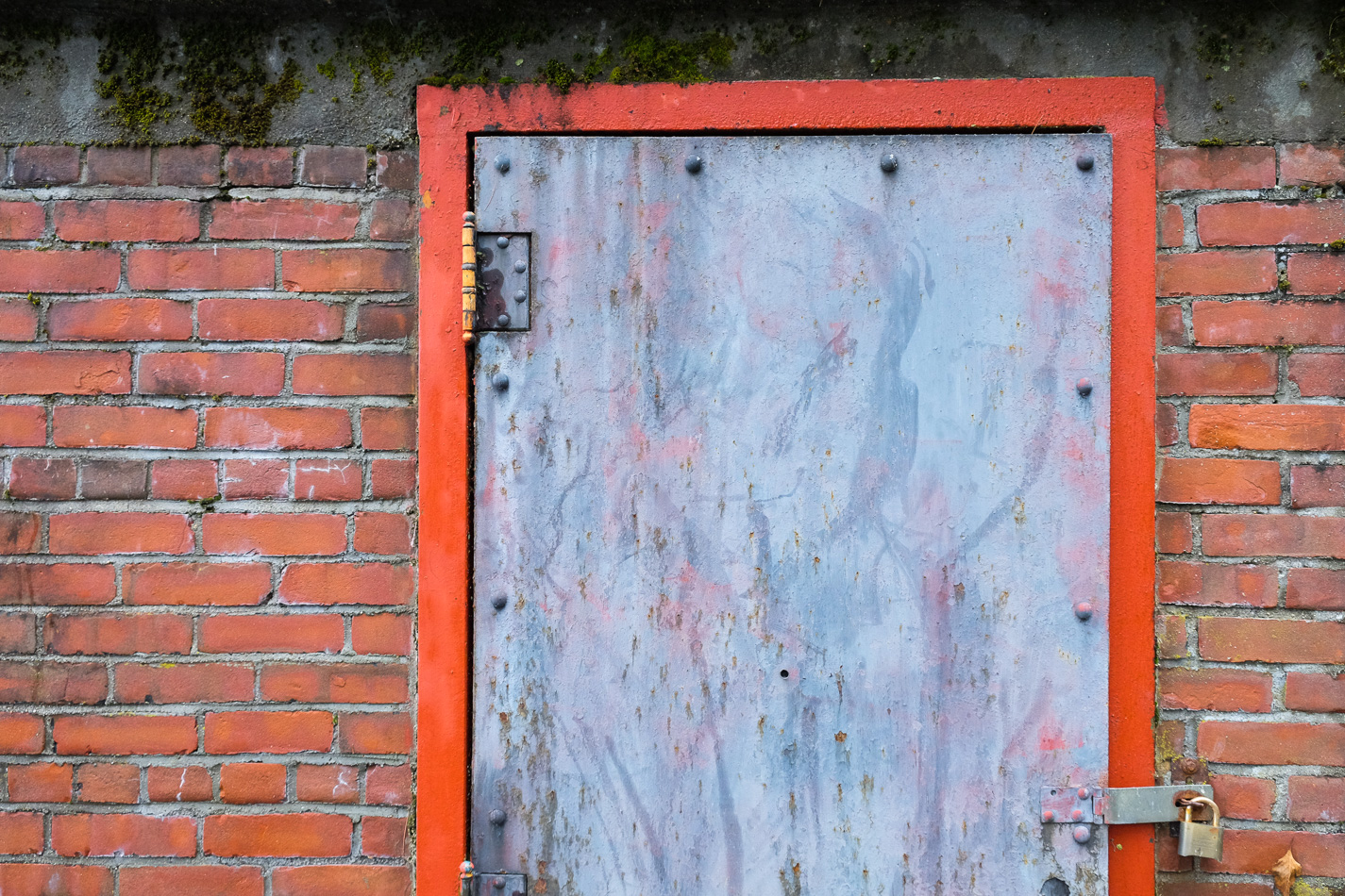 Color photo of a red door frame on a brick building