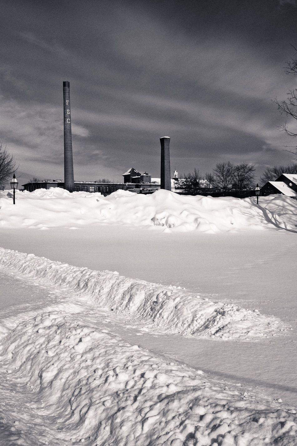 Black and white photo of the large snowbanks at the Colony Mill Marketplace in Keene, NH