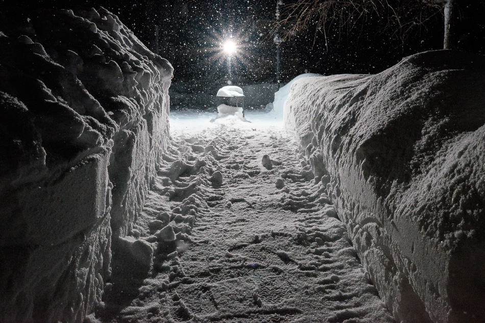 Color photo of a trench through the snow taken at night